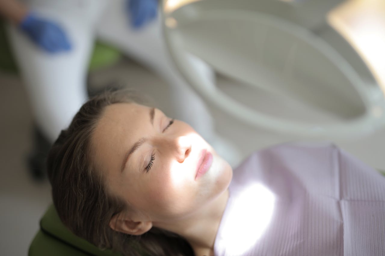 Woman reclining with closed eyes during a medical check-up in a clinical setting.