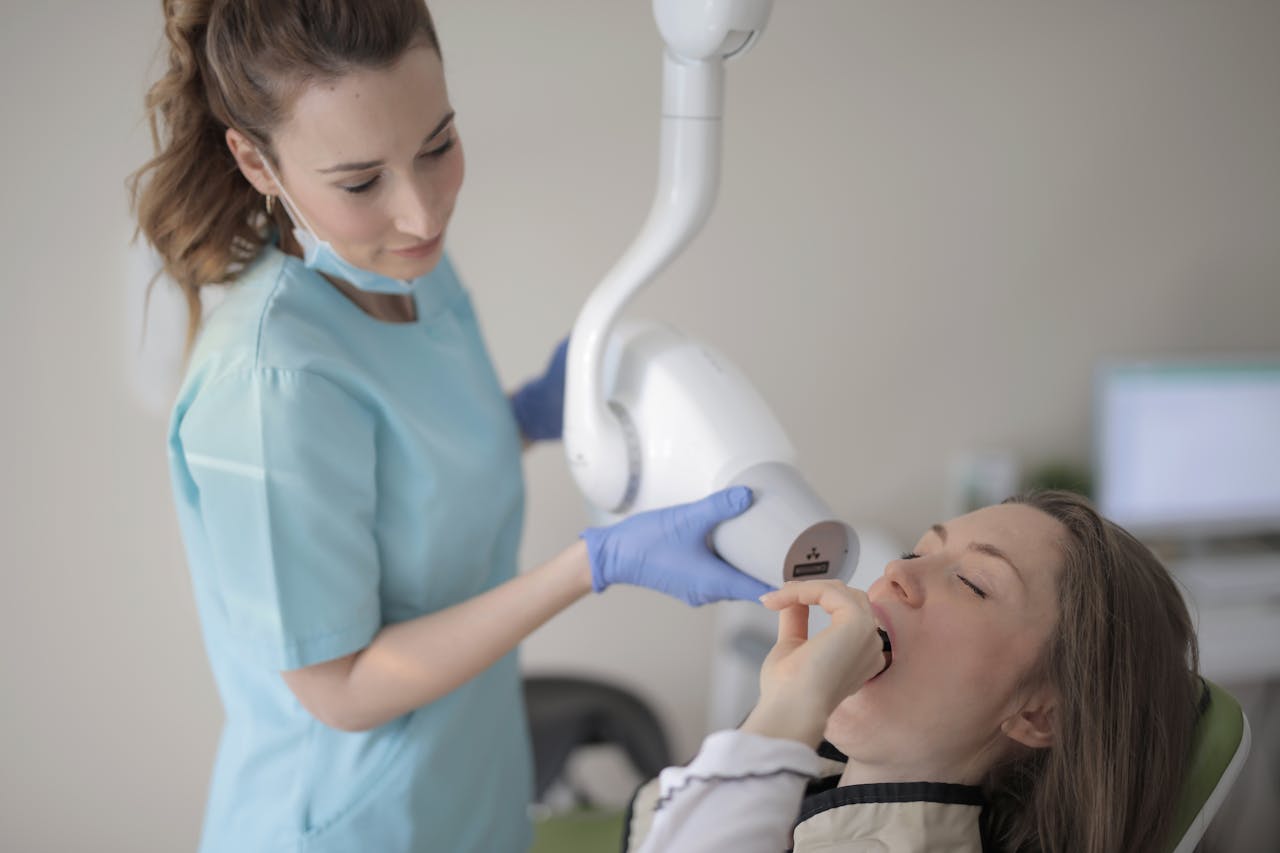 Female dentist conducting an oral X-ray on a patient in a dental clinic.